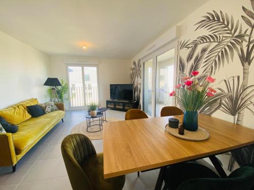un salon avec une table et un canapé jaune dans l'établissement Casa des Ducs, à Angers