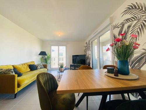 un salon avec une table et un canapé jaune dans l'établissement Casa des Ducs, à Angers