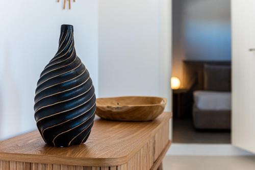a vase sitting on a wooden table with a bowl at Carpe Diem Villas Mykonos ,Heated Pool! in Ornos