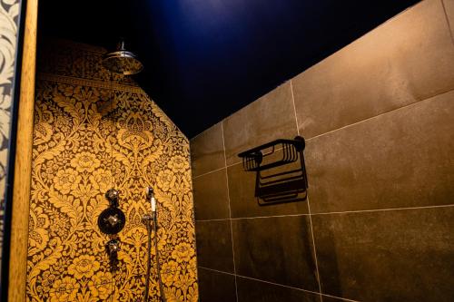 a bathroom with a shower with a tiled wall at Othmar Herberg in Ootmarsum