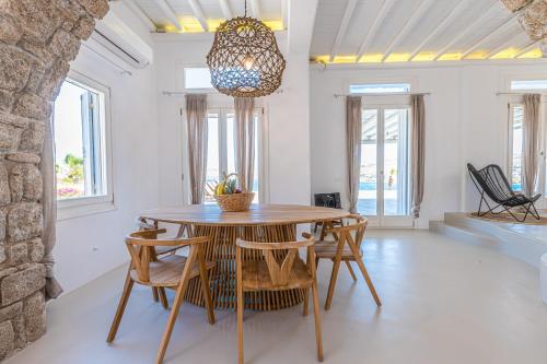 a dining room with a wooden table and chairs at Carpe Diem Villas Mykonos ,Heated Pool! in Ornos