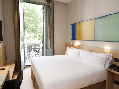 a bedroom with a large white bed and a window at Hotel Àmbit Barcelona in Barcelona