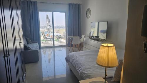 a bedroom with a bed and a view of a patio at LA Perla Studio Near The Beach in Ras al Khaimah