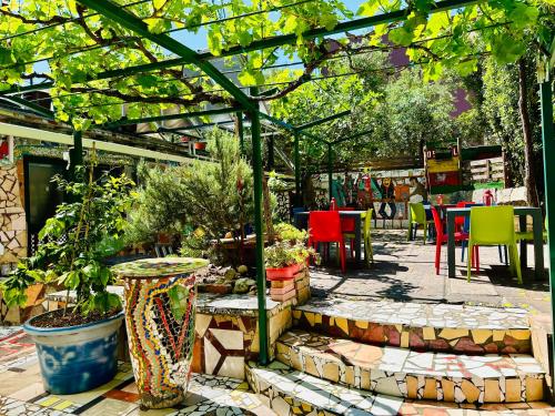 einen Garten mit einer Pergola sowie Tischen und Stühlen in der Unterkunft HOSTEL ART & JOY in Pula