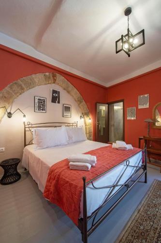 a bedroom with a large bed with red walls at Old Town Corner Luxury Studios in Rhodes Town