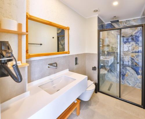 a bathroom with a sink and a shower at Kas Athena Hotel in Kas