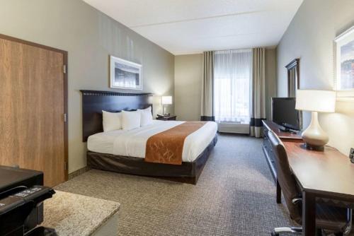 Habitación de hotel con cama, escritorio y TV. en Comfort Inn & Suites ATX North, en Austin