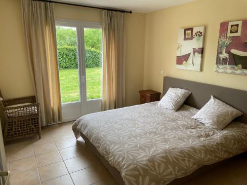 a bedroom with a bed and a large window at maison COSY LES FORGES in Les Forges