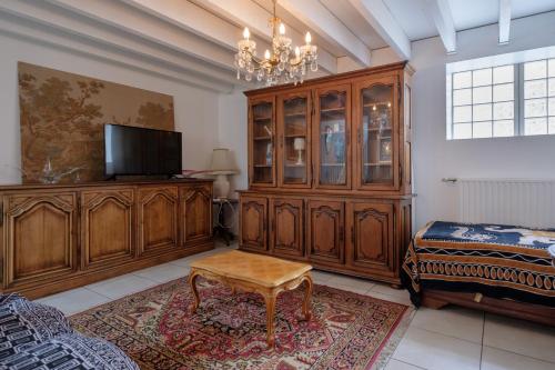 una sala de estar con TV y un gran armario de madera. en ApartHotel François 1er 14eme, en Vitry-le-François