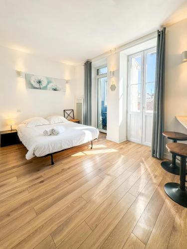 une chambre avec un lit blanc et un parquet dans l'établissement Le Victor Hugo, à Périgueux
