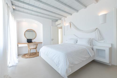 a white bedroom with a white bed and a mirror at Carpe Diem Villas Mykonos ,Heated Pool! in Ornos