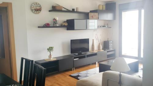 a living room with a flat screen tv on a wall at 2 bedrooms apartement with shared pool and terrace at Ciruena in Cirueña