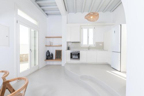 a kitchen with white walls and a large window at Carpe Diem Villas Mykonos ,Heated Pool! in Ornos