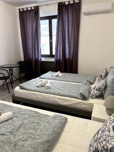 two beds in a room with a window at Aniiza Apartman 2 in Örvényes