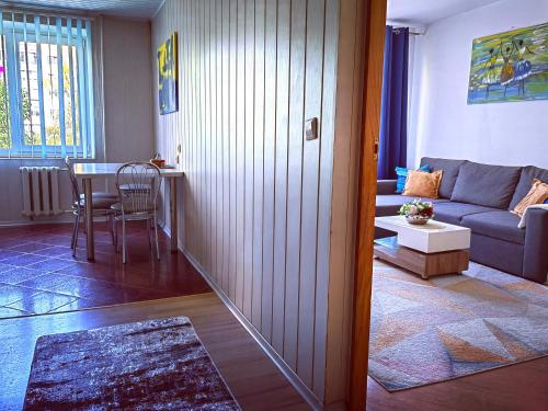 a living room with a couch and a table at Krymo g. Lovely 2 room flat in Šiauliai, near Akropolis in Šiauliai