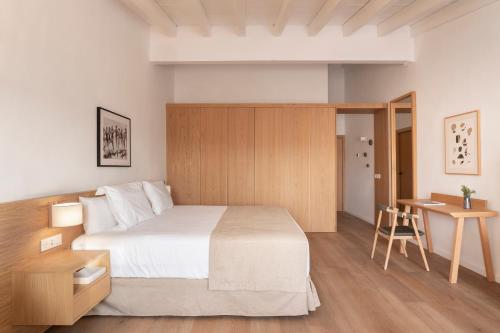 a bedroom with a large bed and a desk at Es Figueral Nou Hotel Rural & Spa - Adults Only - Over 12 in Montuiri