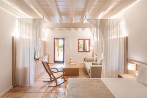 a bedroom with a bed and a living room at Es Figueral Nou Hotel Rural & Spa - Adults Only - Over 12 in Montuiri
