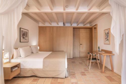 a bedroom with a large bed and a table at Es Figueral Nou Hotel Rural & Spa - Adults Only - Over 12 in Montuiri