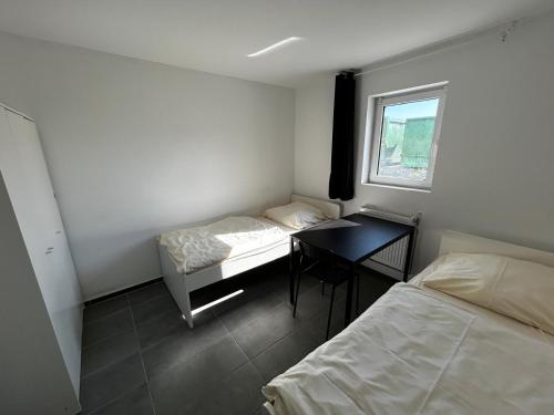 Pokój z 2 łóżkami, biurkiem i oknem w obiekcie Monteurunterkunft Schwaig w mieście Schwaig bei Nürnberg