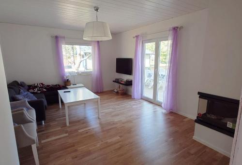 un soggiorno con divano e tavolo di Villa with 4 bed rooms with internet in Vimmerby a Gullringen