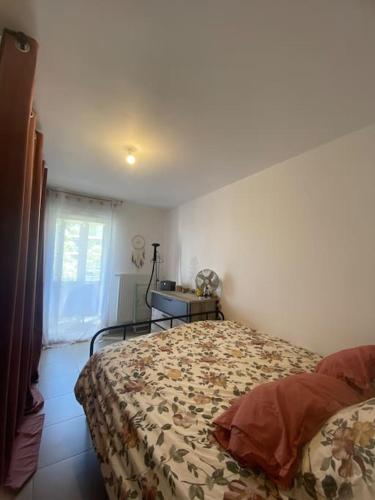 une chambre avec un lit, une table et une fenêtre dans l'établissement Appartement charmant à 10 minutes des plages, à Châteauneuf-les-Martigues