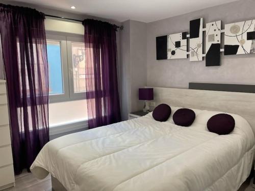ein Schlafzimmer mit einem großen weißen Bett mit lila Vorhängen in der Unterkunft Arostegi central , apto renovado en pleno centro in Bermeo