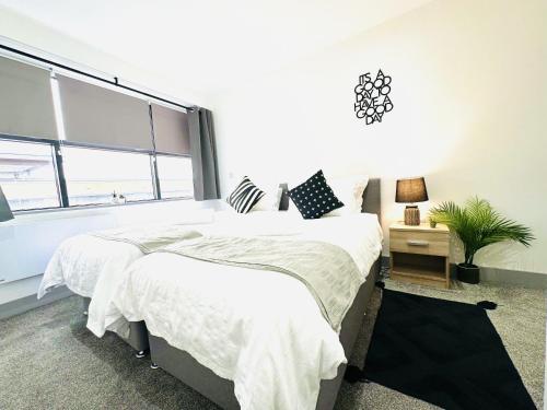 two beds in a bedroom with a large window at 202 Grosvenor House in Wakefield