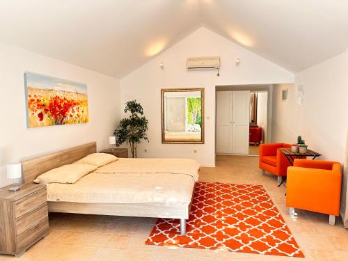 a bedroom with a bed and a orange chair at Sea House Bol in Bol