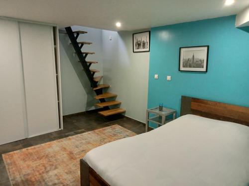- une chambre avec un lit et un mur bleu dans l'établissement WIFI - PARKING - SUPERBE T3 SPACIEUX ET MODERNE!!!!, à Saint-Denis