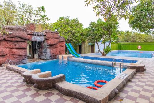 une piscine avec toboggan et un parc aquatique dans l'établissement Daksh Resort And Amusement Park, à Sasan Gir