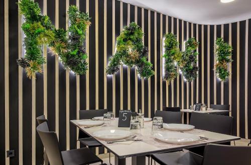 a dining room with a table and chairs with plants at Villa Nani in Podstrana