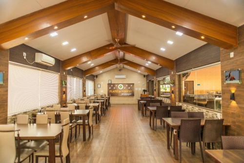 une salle à manger avec des tables et des chaises dans l'établissement Daksh Resort And Amusement Park, à Sasan Gir