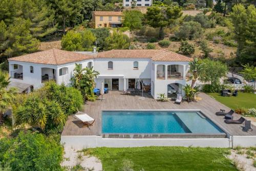 une vue aérienne d'une maison avec piscine dans l'établissement Villa vue mer et pinède, à Bandol