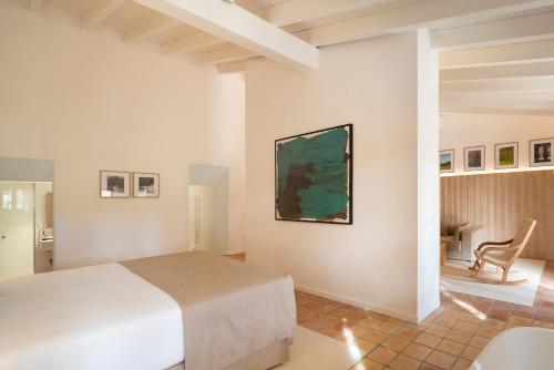 a bedroom with a bed and a chair in a room at Es Figueral Nou Hotel Rural & Spa - Adults Only - Over 12 in Montuiri