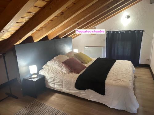 una camera da letto con un grande letto con lenzuola e cuscini bianchi di MAISON DES VIGNES- TROQUAÏROU et BECCA MOTTA a Brides-les-Bains
