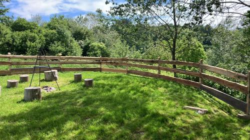 una valla de madera en un campo con césped verde en Przystanek 470 en Krościenko