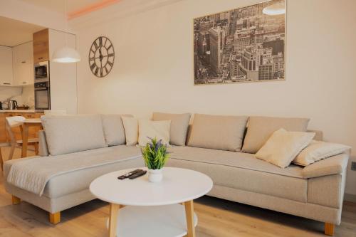 a living room with a couch and a table at 33rd Floor Twin Apartments & 7th Floor Apartment In Cevahir Sky City Complex With Pool, Spa, Fitness and Parking Included In Price in Skopje