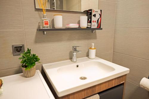 a bathroom with a white sink and a mirror at 33rd Floor Twin Apartments & 7th Floor Apartment In Cevahir Sky City Complex With Pool, Spa, Fitness and Parking Included In Price in Skopje