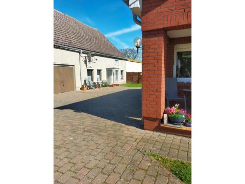 a driveway of a house with a brick wall at Ferienwohnung Mecklenburgische Seenplatte in Schwichtenberg