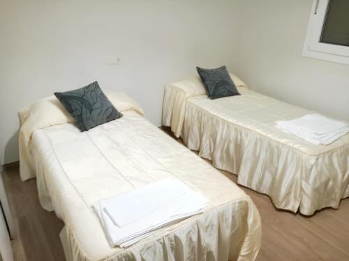 dos camas sentadas una al lado de la otra en una habitación en 4 bedrooms apartement with shared pool furnished terrace and wifi at Villarrobledo, en Villarrobledo