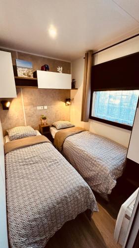 une chambre avec deux lits et une fenêtre dans l'établissement Entre Terre et Mer, à Lège-Cap-Ferret