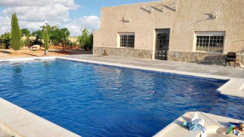 una piscina frente a una casa en 4 bedrooms apartement with shared pool furnished terrace and wifi at Villarrobledo, en Villarrobledo