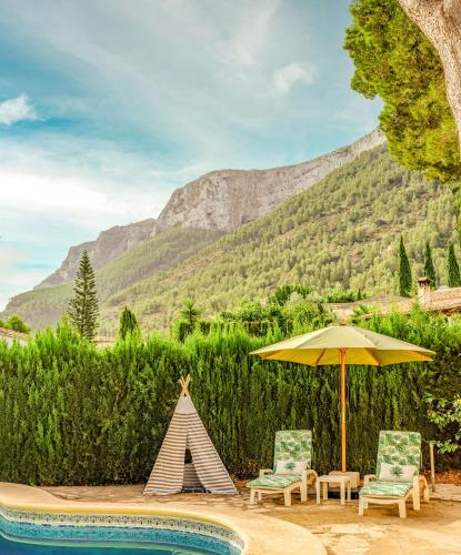 a tent and two chairs and an umbrella next to a pool at LA VILLA MEDITERRANEA DE HERACLES en Denia in Denia
