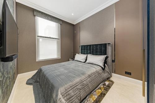 Schlafzimmer mit einem Bett und einem Fenster in der Unterkunft Piccadilly Green Park Apartment in London