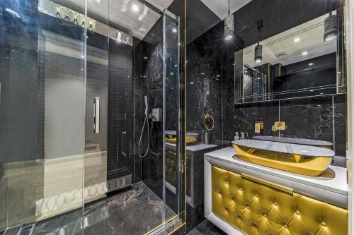 ein Badezimmer mit einer gelben Badewanne und einer Glasdusche in der Unterkunft Piccadilly Green Park Apartment in London