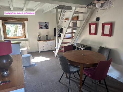 Habitación con mesa, sillas y escalera. en MAISON DES VIGNES- TROQUAÏROU et BECCA MOTTA en Brides-les-Bains