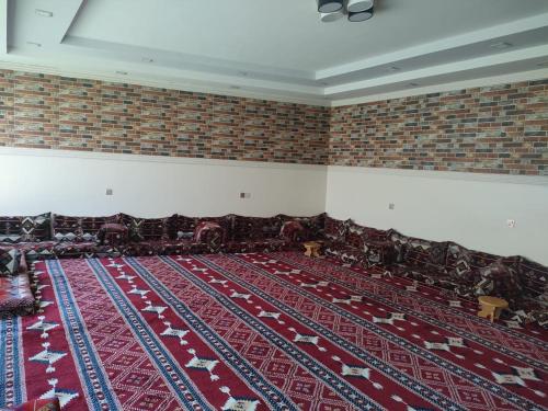 una habitación vacía con sillas y alfombra roja en استراحات توليب أبها, en Qāʼid