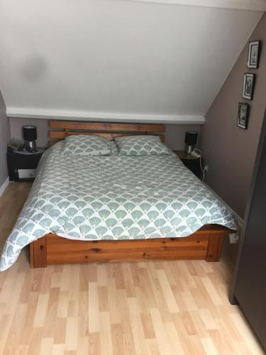 - une chambre avec un lit doté d'un cadre de lit en bois dans l'établissement Claude et Martine, à Villeparisis