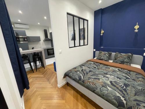 - une chambre avec un mur bleu et un lit dans l'établissement Appart Cosy, Proche Gare, à Nice