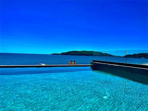 a group of people sitting on a dock in a large body of water at Hotel Ponta Plaza Conference & Spa in Budva